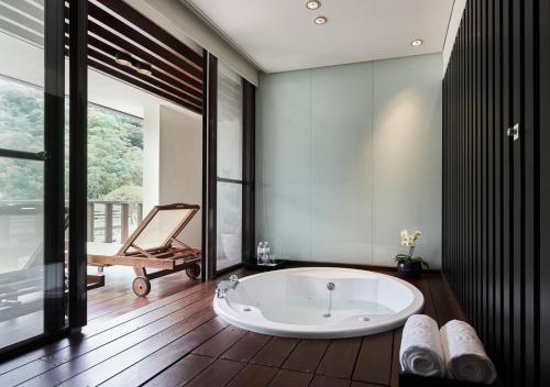 a bathroom with a large tub in a room at Hotel Royal Chiao Hsi in Jiaoxi