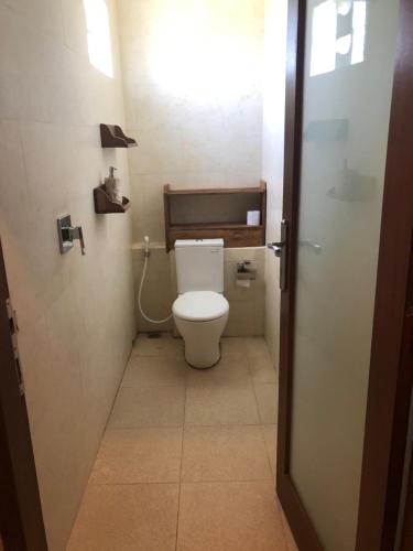 a small bathroom with a toilet in a stall at Melati Bali 2 in Canggu