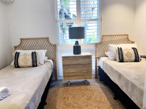 a bedroom with a bed and a lamp at The Hastings Beach Houses in Noosa Heads