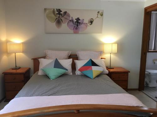 a bedroom with a bed with pillows and two lamps at Farm guests house in Somersby