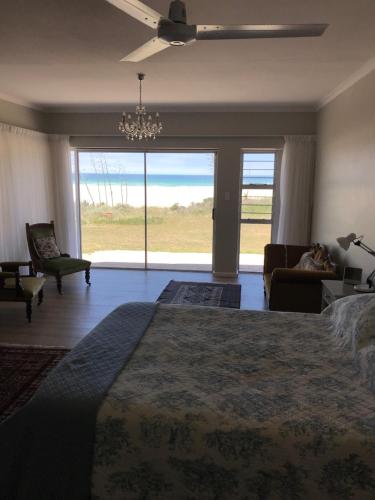a bedroom with a large bed and a large window at 39 Kabeljauws Road Beach House in Jeffreys Bay