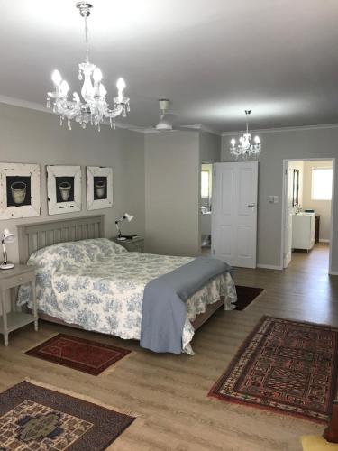 a bedroom with a bed and a chandelier at 39 Kabeljauws Road Beach House in Jeffreys Bay