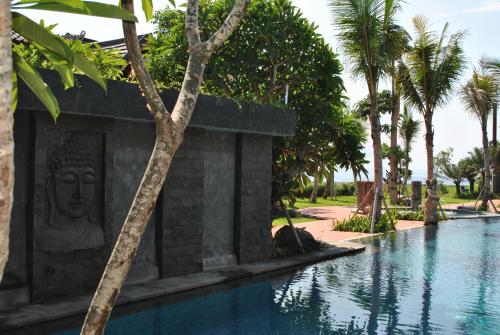a pool at the resort with a statue next to it at Kori Maharani Villas & Resort in Keramas