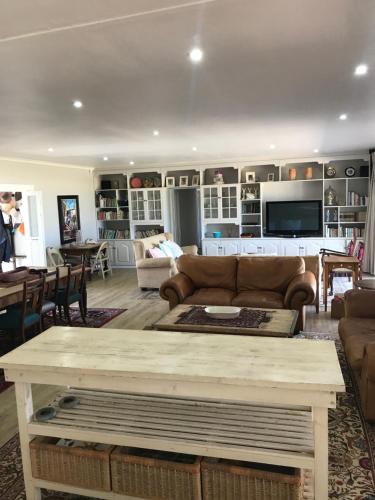 a living room with a couch and a table at 39 Kabeljauws Road Beach House in Jeffreys Bay