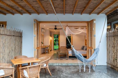 a hammock in the living room of a villa at Chi-Bu Riverside in Nhơn Trạch