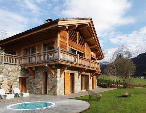 a log cabin with a balcony on the side of it at Chalet La Vigogne - Spa & Hammam - 14 pers in Le Grand-Bornand