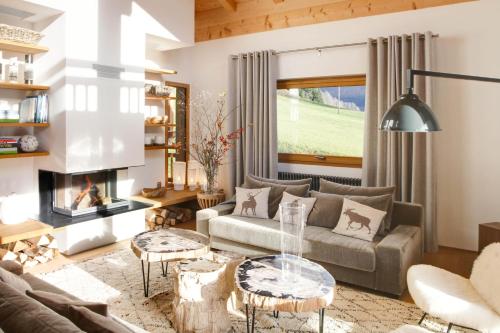 a living room with a couch and a fireplace at Chalet La Vigogne - Spa & Hammam - 14 pers in Le Grand-Bornand