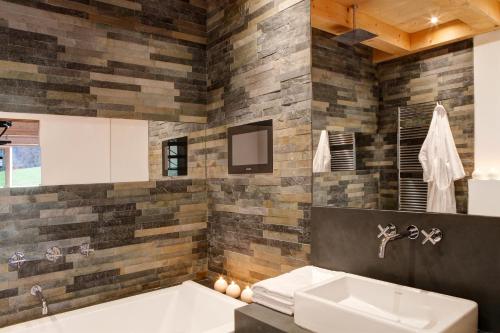 a bathroom with a tub and a sink at Chalet La Vigogne et Spa in Le Grand-Bornand