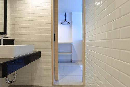 a bathroom with a white sink and a toilet at Port Canary Airport Hotel in Lat Krabang