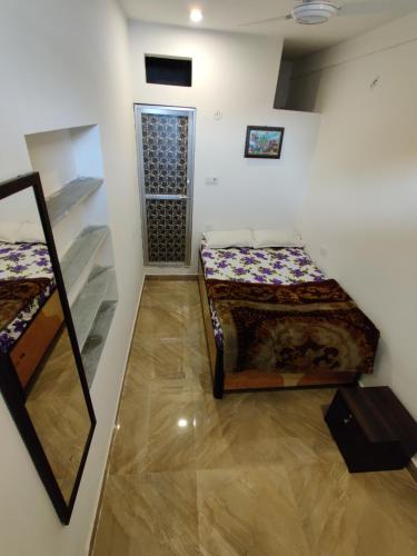 a room with two beds and a mirror in it at Varah Square Guest House in Pushkar