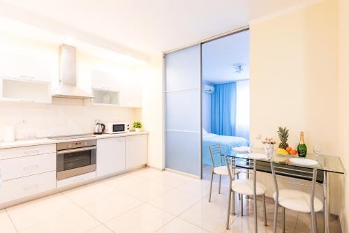 a kitchen and dining room with a table and chairs at Шикарные апартаменты 3 минуты пешком от м Позняки in Kyiv