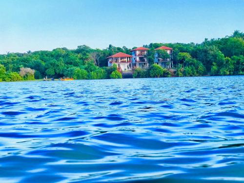 a large body of water with houses in the background at Ashansa Lagoon Resort in Tangalle