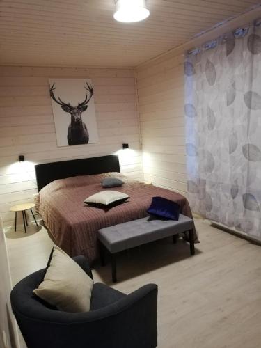a bedroom with a bed and a chair in a room at Ammatour Apartments in Uro