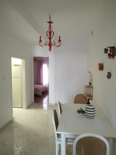 uma sala de jantar branca com uma mesa e cadeiras brancas em Michali's Koukaki Apartment (metro Sygrou/Fix) em Atenas