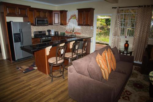 sala de estar con sofá y cocina en Jean's ( 1 or 2 B/R ) Condo, Sapphire Estate,Laborie ,St Lucia. Comfort in Style., en Laborie