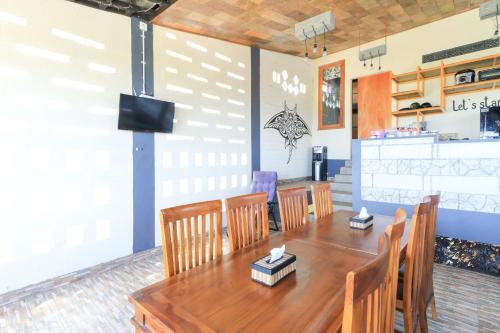 珀尼达岛Hostel Bukit Sangcure的配有木桌椅的餐厅