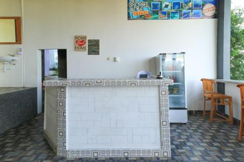 a kitchen with a refrigerator and a table at Hostel Bukit Sangcure in Nusa Penida