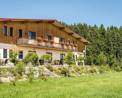 ein Haus mit einem Balkon mit Blumen darauf in der Unterkunft Ferienwohnungen Gut Fasanenhöhe in Chieming