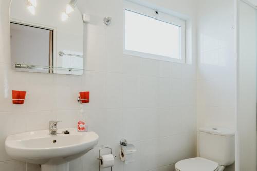 a white bathroom with a sink and a mirror at City View Gardens I in Funchal