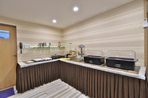 a kitchen with a counter with three pans on it at HOTEL LE GRAND in Surat