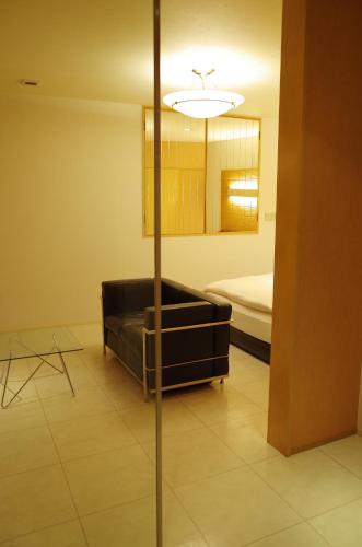 a living room with a couch and a bed at Hotel JOYCE in Saijō-chō
