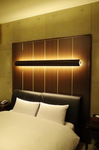 a bedroom with a bed and a light above it at Hotel JOYCE in Saijō-chō