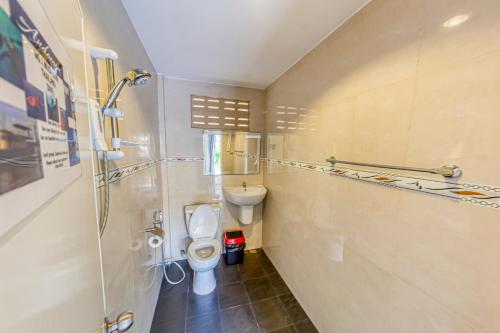 a small bathroom with a toilet and a sink at The Travelers Friend in Ko Lanta