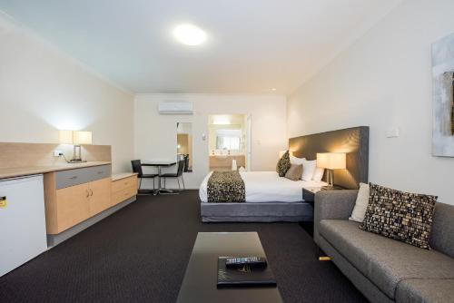 a hotel room with a bed and a couch at Coral Cay Resort in Mackay