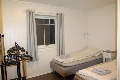 a room with two twin beds and a window at Best of Lyngen panorama apartment in Lyngseidet