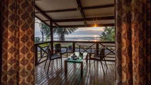 a room with a balcony with a view of the ocean at SaffronStays Little Paradise, Murud in Murud