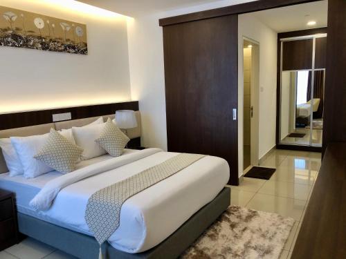 a bedroom with a large bed with white sheets and pillows at Sky D'Mont Suites in Genting Highlands