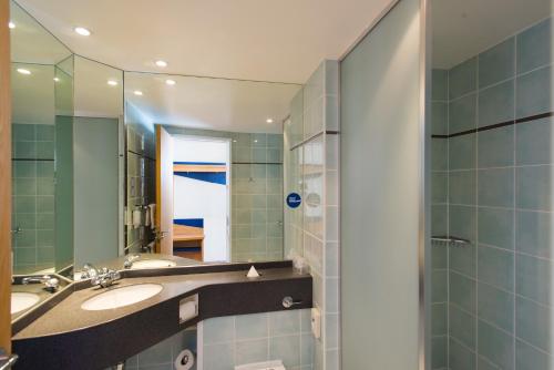 a bathroom with two sinks and a mirror at Holiday Inn Express Bradford City Centre, an IHG Hotel in Bradford