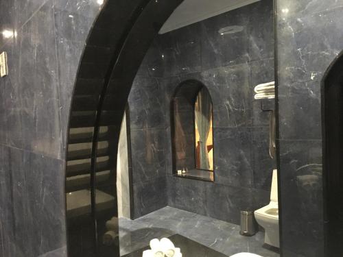 a black bathroom with a toilet and a mirror at Rose Heritage Home in Varanasi