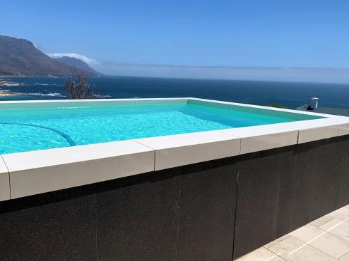 a swimming pool with the ocean in the background at 6 on Clifton - Spacious 2 bedroom apartment in Cape Town