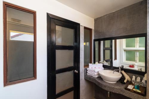 a bathroom with a sink and a mirror at Amber Angkor Villa Hotel & Spa in Siem Reap