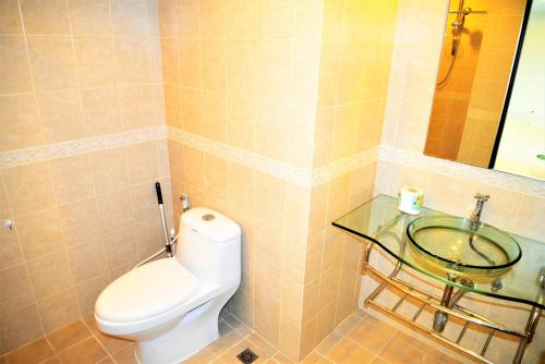 ein Badezimmer mit Toilette und Glaswaschbecken in der Unterkunft Park Lane Resort Pattaya 2 bedroom condo fully equiped in Jomtien Beach