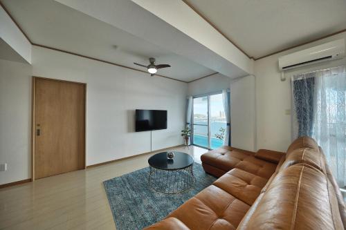 a living room with a couch and a table at FreedomHillsフリーダムヒルズA棟 in Tomigusuku