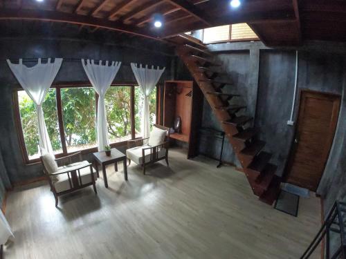 a room with a staircase and chairs and windows at Blue Heaven Resort Koh Tao in Koh Tao