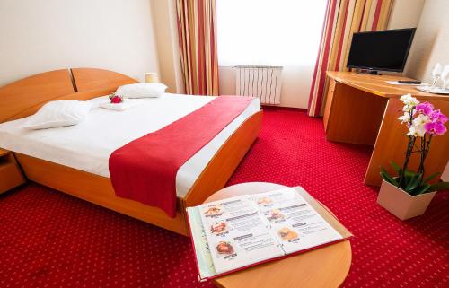 a hotel room with a bed with a red carpet at Hotel Dana in Satu Mare