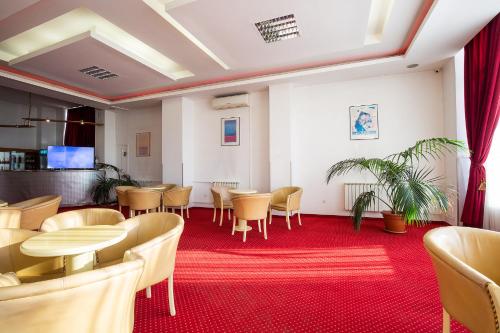 a restaurant with tables and chairs and a red carpet at Hotel Dana in Satu Mare