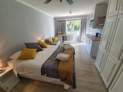 a bedroom with a large bed with yellow pillows at Joey's Rooms in Stellenbosch