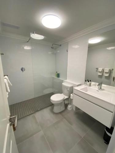 a white bathroom with a toilet and a sink at Lemon Rind - 205 Oude Hoek in Stellenbosch
