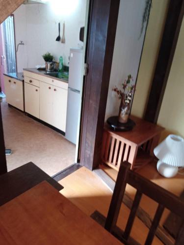 a kitchen with a table and a white refrigerator at HAKUBA IKEDA LIFE KAN APARTMENTS in Hakuba