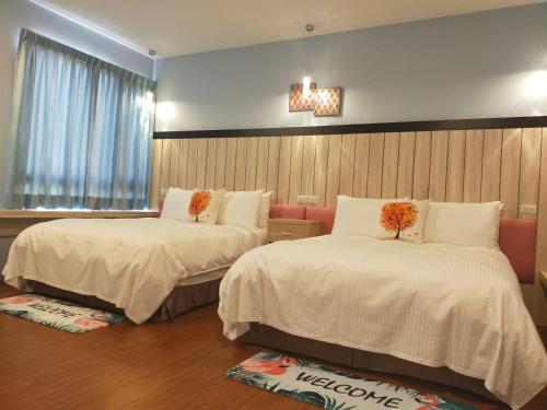 員林的住宿－歐鄉莊園，酒店客房设有两张床和窗户。