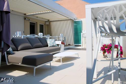 un patio con sofá y mesa en Malù Bed&Breakfast, en Polignano a Mare