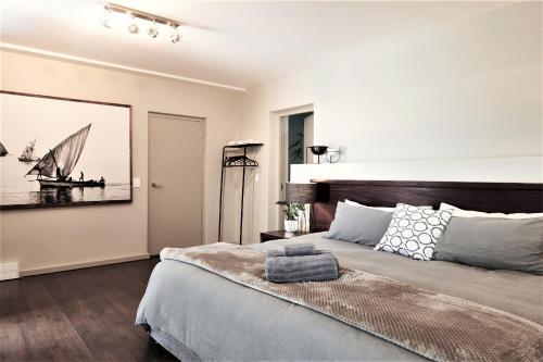a bedroom with a bed and a picture of a sailboat at 6 on Clifton - Spacious 2 bedroom apartment in Cape Town