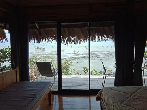 Cette chambre comprend un lit et offre une vue sur la plage. dans l'établissement wetlandcamp บ้านชายเล, à Phatthalung
