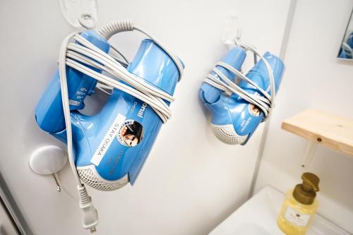 a bathroom with blue and white cleaning equipment hanging on a wall at Stay Osaka Namba in Osaka
