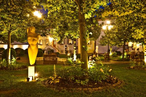 a park at night with a sculpture of a woman at Schloss Reinach in Freiburg im Breisgau