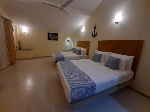 een slaapkamer met 2 bedden in een kamer bij Ayana Beach in Ja-Ela